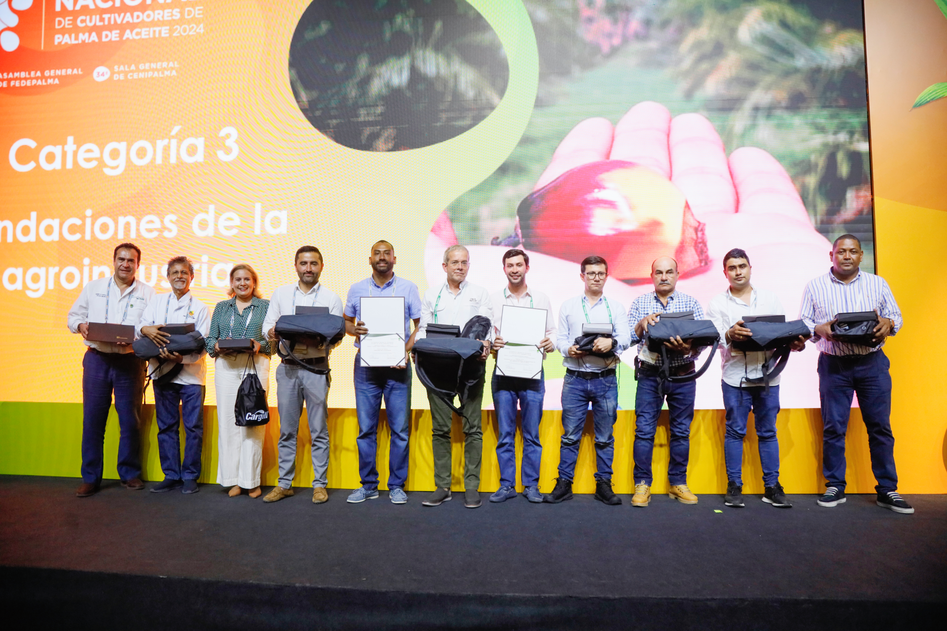 Grupo de diez personas recibiendo premios durante una ceremonia del Congreso Nacional de Cultivadores de Palma de Aceite 2024